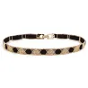 Elegant black elastic belt - with golden metal decorationsBelts
